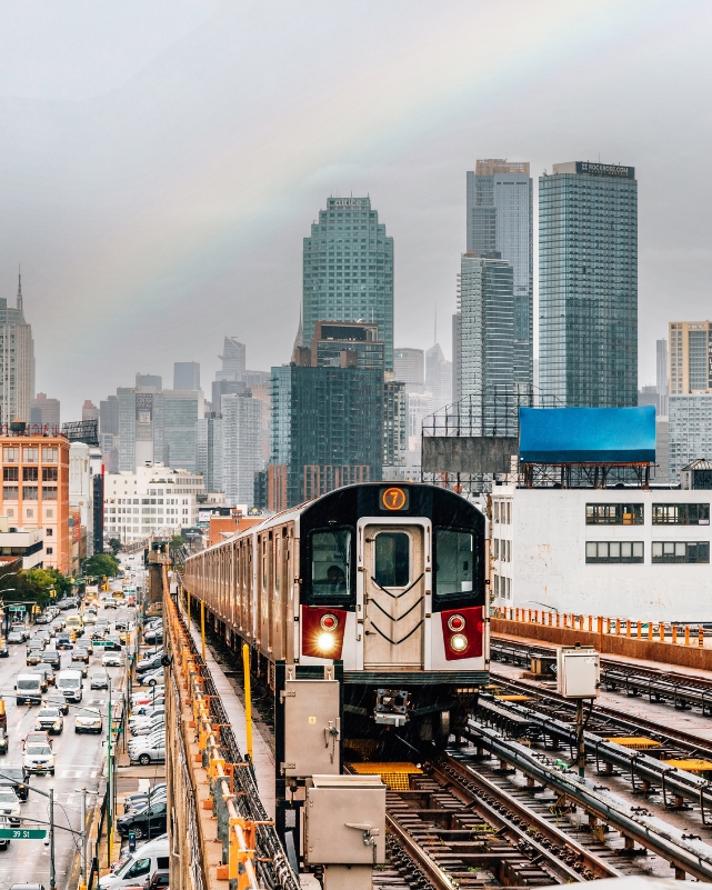 Image of a subway train approaching an elevated subway station in Queens